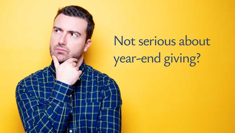 Man thinking against yellow background with text “Not serious about year-end giving?” suggesting hesitation about nonprofit fundraising decisions