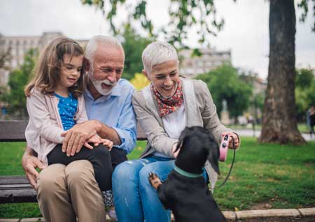 Grandparents with granddaughter and black dog
