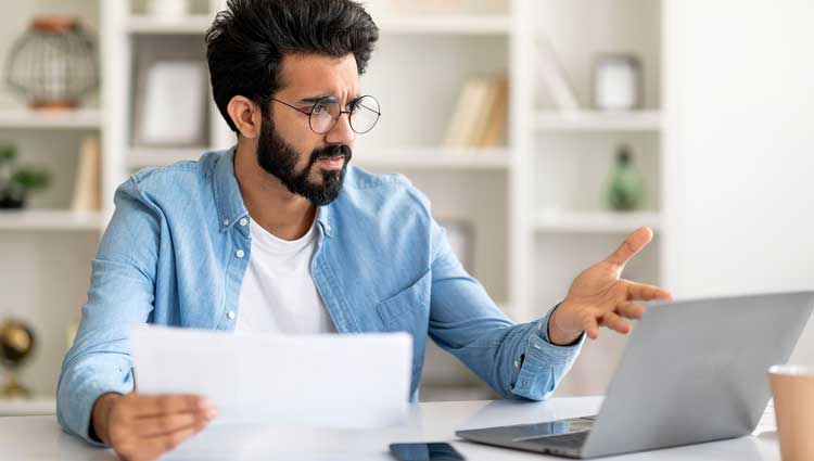 Male nonprofit executive worried about budget in front of laptop