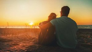 Couple on beach watching sunset