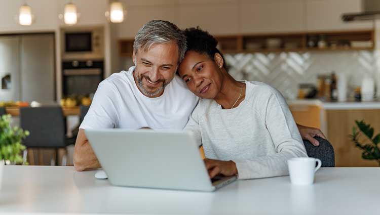 A couple looking at a laptop computer together, to illustrate the concept of online will creation.