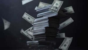 Stack of U.S. hundred dollar bills flying through the air against a dark background, symbolizing money and donations