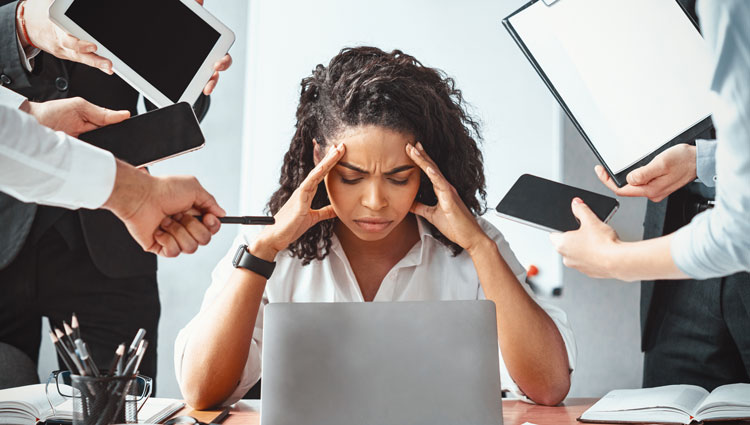 Overwhelmed nonprofit professional surrounded by distractions, symbolizing toxic busyness and poor time management