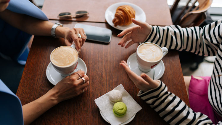 Two people having a quiet conversation over coffee, representing a personal donor conversation about legacy giving.